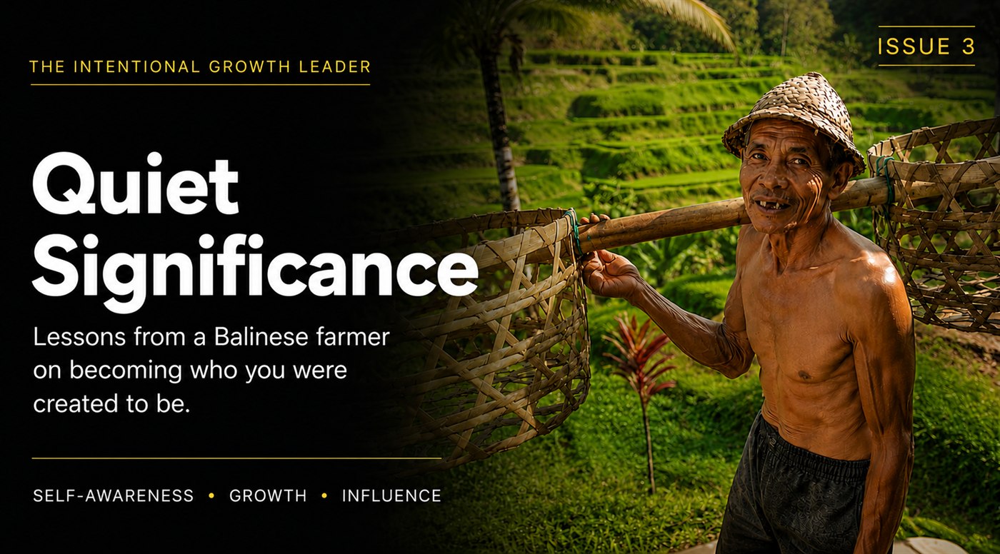 An elderly Balinese farmer carrying a bamboo pole and two woven baskets across his shoulders, in front of terraced rice fields in Ubud.